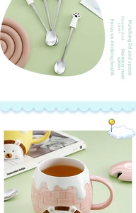 Detail of cartoon cat paw ceramic mug with matching lid and stainless steel spoon