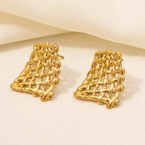 Macro detail of 304 stainless steel golden earrings with irregular woven mesh texture