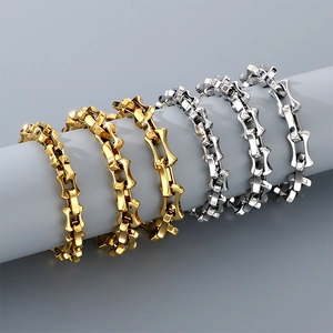 Macro shot of gold and silver curved bone link bracelets displayed on a grey cylinder