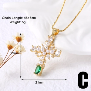 Detail showing 45+5cm gold cross necklace dimensions with pearls and green gemstone