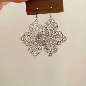 Détail de boucles d'oreilles mandala en filigrane argenté avec design à franges