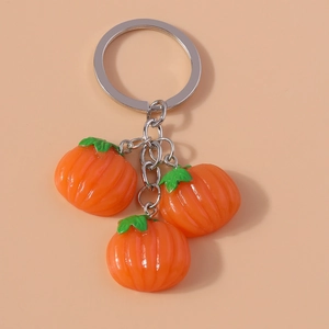 Detail of orange pumpkin keychain featuring three resin pendants on a silver chain