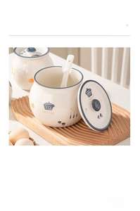 Detail of white ceramic seasoning jar with lid, spoon, and wooden tray for kitchen storage