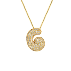 Macro detail of 18K gold plated letter G pendant with cubic zirconia stones