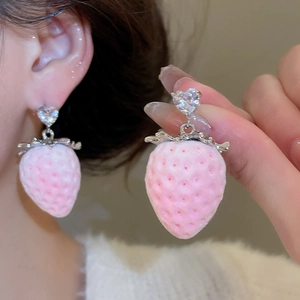 Detail of pink strawberry earrings with silver metal base and heart shaped cubic zirconia