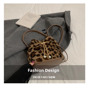 Detail of leopard print faux fur bucket bag with pearl drawstrings and gold chain