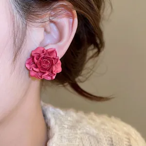 Elegant hot pink resin rose earrings on model showcasing 3D floral texture and style