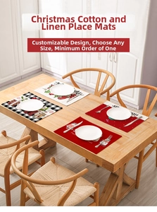 Detail showing four Christmas linen placemats with reindeer and santa patterns on wood