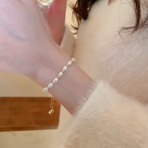 Close-up of elegant freshwater pearl bracelet with adjustable golden slider on wrist