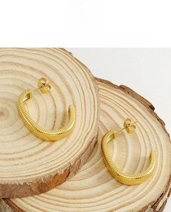 Detail von 18K vergoldeten Edelstahl-Creolen in C-Form mit feiner Rillenstruktur