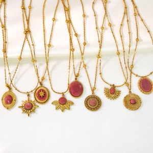 French vintage style gold necklaces with pink rhodochrosite pendants on white silk