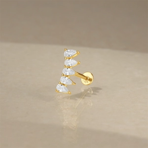 Macro shot of gold S925 sterling silver stud earring with five sparkling pear-cut zircons