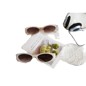Retro oval cat-eye sunglasses in champagne and white frames with dark lenses