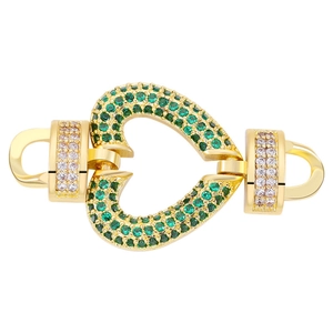 Close-up of gold jewelry clasp connector heart-shaped with green and clear zircon stones