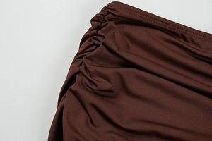 Detailed view of the dark brown knitted fabric with elegant side ruched gathering