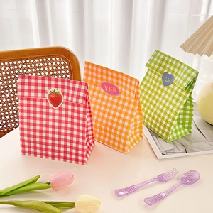 Close-up of pink, orange, and green checkered gift bags with cute decorative stickers