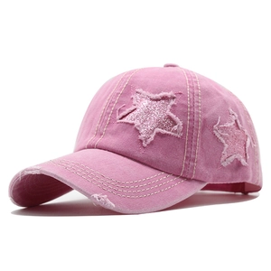 Détail de la casquette rose en coton avec patch étoile effiloché et finition pailletée