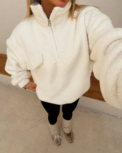Detail of white sherpa fleece half-zip sweatshirt with high collar and chest pocket