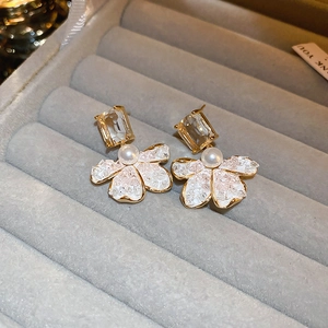 Macro detail of elegant flower earrings with white petals and pearls in a velvet jewelry box
