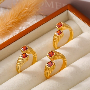 Vintage gold spiral ring with red square zircon stones displayed in a beige jewelry box