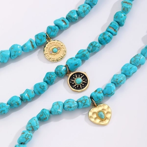 Close-up of bohemian turquoise beads with gold evil eye and heart charms on necklace