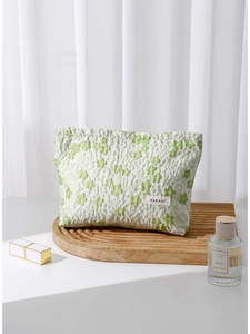 Green floral cosmetic bag on a wooden stand with elegant perfume and makeup accessories