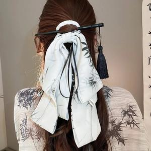 Detail of silk hair ribbon with bamboo patterns and black hair stick with tassel