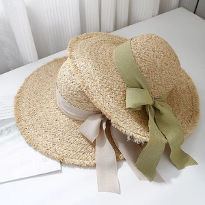 Elegant wide brim raffia sun hats with green and beige bow ribbons for summer beach travel
