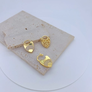 Tre pendenti a cuore in oro con micro-pavé di zirconi su superficie in pietra naturale