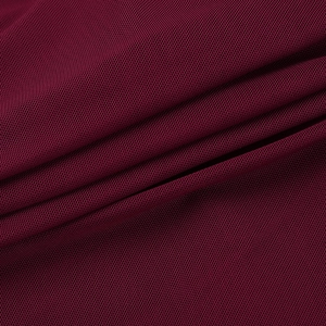 Gros plan sur le tissu en maille rouge vin montrant la texture douce et les plis