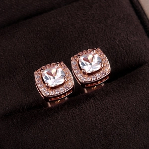 Macro view of square-cut halo stud earrings in rose gold finish with zircon inlay