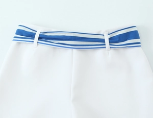 Detail of white shorts with blue striped sash belt and high-quality fabric texture
