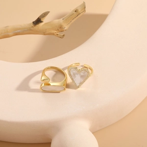 Close-up of golden adjustable rings with heart-shaped shell and zircon inlay