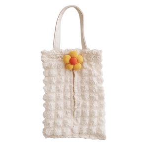 Detail of cream bubble crinkle fabric tissue holder with decorative floral accent