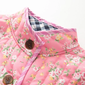Détails de la veste matelassée fleurie avec col montant et gros bouton marron foncé