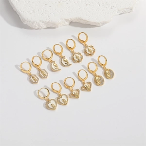 Detailed collection of gold earrings with religious motifs and white zircon accents