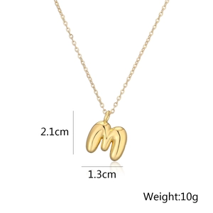 Dettaglio ciondolo lettera M dorata con dimensioni 2,1cm per 1,3cm e peso di 10g