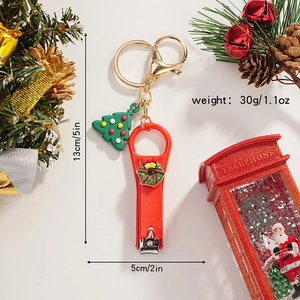 Detailed view of red Christmas wreath nail clipper keychain with a green tree charm