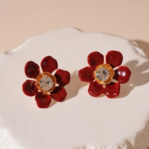 Macro shot of vintage dark red flower earrings with central crystal on stone display
