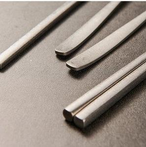 Close-up of vintage snowflake grey stainless steel chopsticks and spoon handles with matte finish
