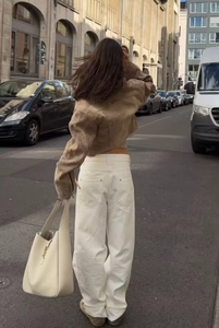 Vista posteriore della giacca con stampa tie-dye e pantaloni bianchi in strada europea