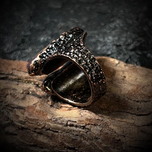 Détail macro d'une bague vintage en bronze avec améthystes et texture brute de météorite