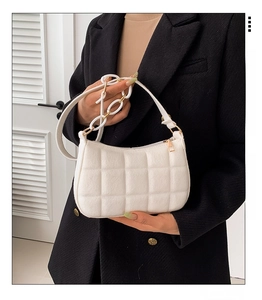 Detail einer weißen Stepptasche mit schicker Kettenhenkel und goldener Reißverschluss