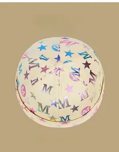 Vue détaillée de dessus du bonnet docker beige avec lettres M colorées et motifs étoiles