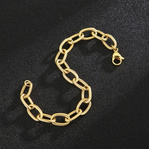 Detailed close-up of golden twist chain bracelet with a lobster clasp on a black surface