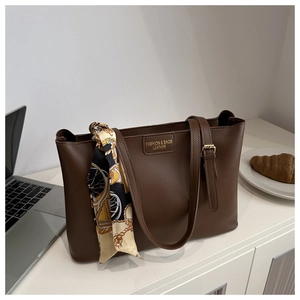 Detailaufnahme der braunen Kunstleder-Tote-Bag mit dekorativem Seidenschal und Prägung