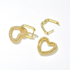 Minimalist gold heart earrings with pavé zircon accents on a clean white background