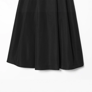 Vista frontale di gonna midi in denim nero con pieghe strutturate e design minimalista
