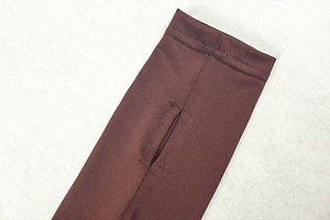 Close-up of brown elastic knit sleeve cuff featuring a thumb hole and precise stitching