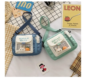 Flachbild von blauen und grünen Stofftaschen mit niedlicher Hasen-Deko und Klarsichtfach